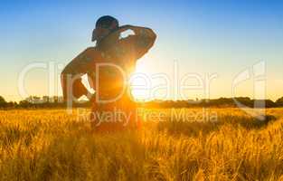 African woman in traditional clothes standing in a field of crop