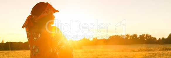 African woman in traditional clothes standing in a field of crop