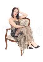 Beautiful woman sitting in armchair in a long dress