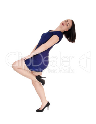 Woman standing in a blue tight dress bending backwards