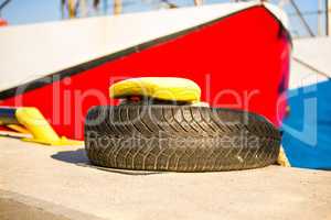 bollard with mooring line and red and blue ship in the background