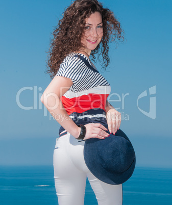 Portrait of a girl with a hat against the sea