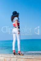 The girl in white jeans looks into the sea distance