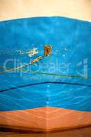 Mooring line of a trawler in backlight with water reflections