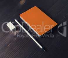 Orange notepad, pencil, eraser
