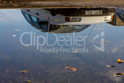 Car reflected in puddle