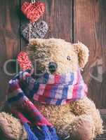 brown soft teddy bear sit on a brown wooden background