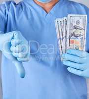 doctor in blue uniform and latex gloves keeps one hand a lot of