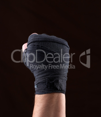 male  hand is wrapped in a black sports textile bandage