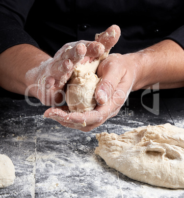 cook making dough balls on a black wooden table