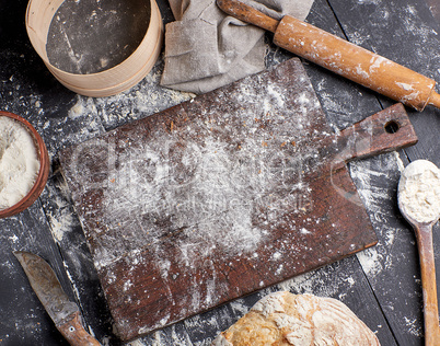 bread, white wheat flour, wooden rolling pin and old cutting boa