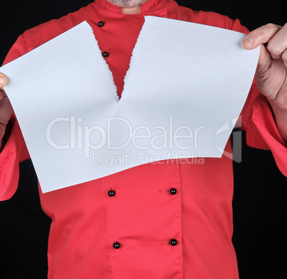 chef in red uniform holding a blank white sheet and tearing it i