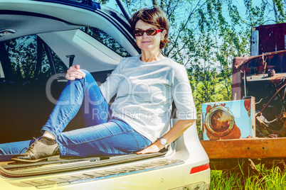 Woman sitting in trunk of car