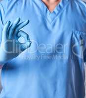 doctor in blue uniform and latex sterile gloves shows an approva
