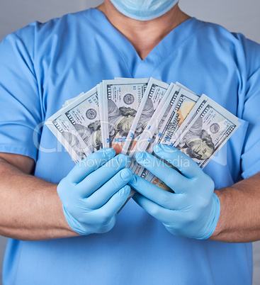 doctor in blue uniform and latex sterile gloves holds a lot of p