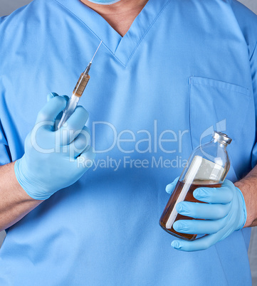 doctor in blue uniform and latex sterile gloves holding a syring