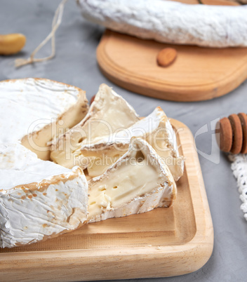 round brie cheese on a wooden cutting board