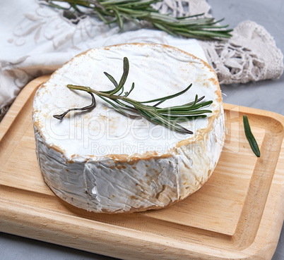 round brie cheese on a wooden cutting board