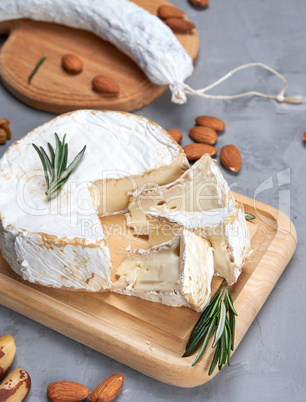 round piece of brie cheese and sausage on a wooden board