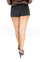 The legs of a young woman in black shorts
