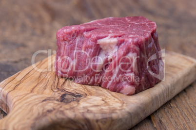 rohes Steak auf dunklem Holz