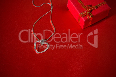 Heart pendant on a red satin background