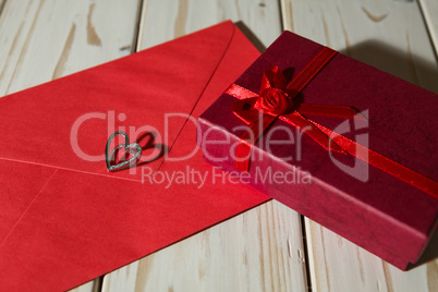 Silver heart pendant on a red envelope and gift box
