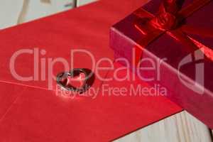 Closeup of a silver heart pendant on a red envelope and gift box