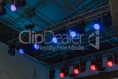 Professional lighting equipment installed above the stage on special metal frames.