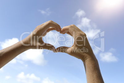 Female hands in front of blue sunny sky, vacation concept