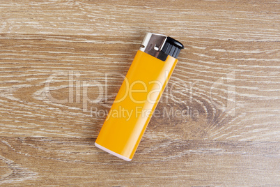 Orange lighter on wooden background