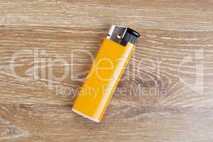 Orange lighter on wooden background