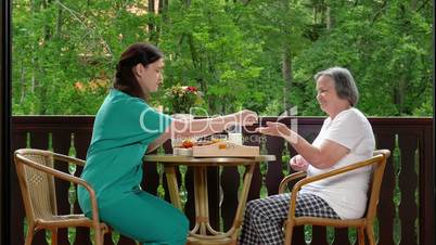 Home caregiver giving medicine to senior woman