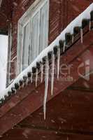 Brown house roof with icicles.