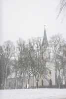 Winter landscape with snow covered church and trees.