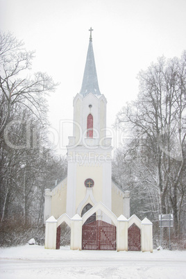 Winter landscape with snow covered church and trees.