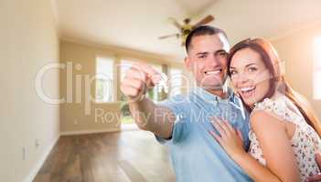 Young Military Couple with House Keys In Empty Room of New Home