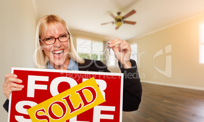 Attractive Young Woman with New Keys and Sold Real Estate Sign