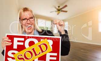 Attractive Young Woman with New Keys and Sold Real Estate Sign