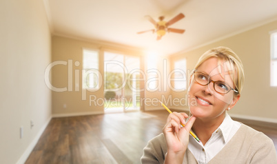 Attractive Woman with Pencil In Empty Room of House