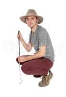 Young man crouching in safari hat