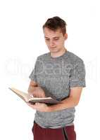 Young man standing reading his book