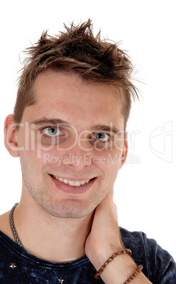 Smiling young man standing with hand on neck