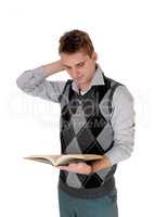 Young man standing reading his book hand on head