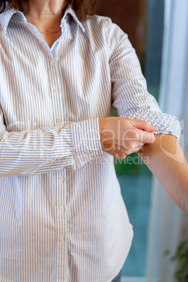 Woman is rolling up sleeves of her blouse