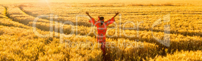 African woman arms raised in a field of crops at sunset or sunri
