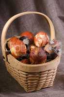 Speckled eggs in basket on brown background.