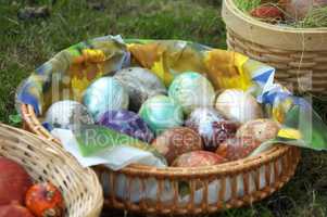 Speckled eggs in basket on grass.