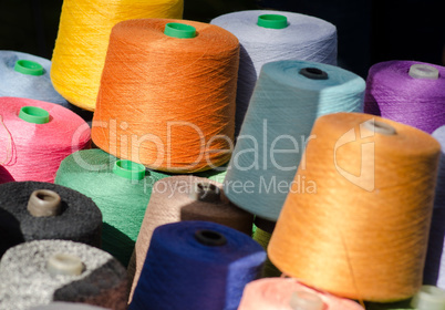 Colorful thread spools as background.