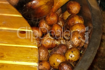 Potatoes with peel in pan in outdoor.